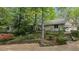 Beautiful home with stone retaining wall, lush landscaping, and garage at 5251 Powers Ferry Rd, Atlanta, GA 30327