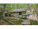 Charming exterior with a stone walkway, mature landscaping, and a three-car garage at 5251 Powers Ferry Rd, Atlanta, GA 30327