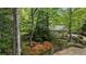 View of the house featuring stone retaining wall and mature trees at 5251 Powers Ferry Rd, Atlanta, GA 30327