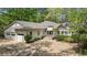 Charming home with a two-car garage, well-manicured landscaping, and a welcoming facade with mature trees at 5251 Powers Ferry Rd, Atlanta, GA 30327