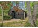 Secluded home exterior featuring dark siding, surrounded by lush trees at 5251 Powers Ferry Rd, Atlanta, GA 30327