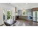 Modern kitchen with stainless steel appliances, sleek cabinetry, and a dining area at 5251 Powers Ferry Rd, Atlanta, GA 30327