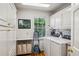 Well-lit laundry room with white cabinets, modern appliances, and hardwood floors at 5251 Powers Ferry Rd, Atlanta, GA 30327