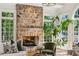 Living room featuring a stone fireplace, many windows, and an inviting seating area bathed in natural light at 5251 Powers Ferry Rd, Atlanta, GA 30327