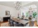 Inviting open-concept living and dining area with beautiful lighting, stone fireplace, and hardwood floors at 5251 Powers Ferry Rd, Atlanta, GA 30327