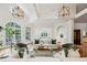 Airy living room with high ceilings, stylish lighting, hardwood floors, and expansive windows showcasing lush outdoor views at 5251 Powers Ferry Rd, Atlanta, GA 30327