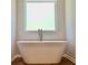 Bathroom featuring a stand alone tub with a window at 678 Egrets Landing #63, Covington, GA 30014