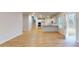 Open-concept space featuring modern flooring, stairs, and an adjacent kitchen with white cabinets at 678 Egrets Landing #63, Covington, GA 30014