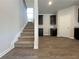 Carpeted staircase leading to the second floor, adjacent to the kitchen and dining area at 678 Egrets Landing #63, Covington, GA 30014