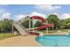 A vibrant water slide enhances the community pool, surrounded by lush landscaping and lounge chairs at 678 Egrets Landing #63, Covington, GA 30014