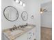 Bright bathroom featuring a double vanity with granite countertop and modern fixtures at 135 Kimbell Farm Dr, Locust Grove, GA 30248