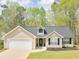Charming single-story home features a manicured lawn, attached garage, and inviting front entrance at 135 Kimbell Farm Dr, Locust Grove, GA 30248
