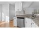 Bright kitchen featuring stainless steel dishwasher, granite countertops, and white cabinets at 135 Kimbell Farm Dr, Locust Grove, GA 30248