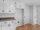 Pantry room with granite counters and white cabinets near a door, laundry hookups at 135 Kimbell Farm Dr, Locust Grove, GA 30248