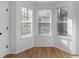 Bright room featuring a bay window with three windows, wood floors and white paint at 135 Kimbell Farm Dr, Locust Grove, GA 30248