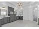 An open bathroom with a marble floor, double vanities, chandelier, and a glass-doored shower at 2114 Castlewycke Ct, Marietta, GA 30068