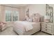 This bedroom is decorated in pinks and whites and has a window with plantation shutters at 2114 Castlewycke Ct, Marietta, GA 30068