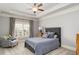 This bedroom is painted gray and has a ceiling fan, reading chair and window with shutters at 2114 Castlewycke Ct, Marietta, GA 30068