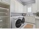 Bright laundry room with front load washer and dryer, and custom cabinets at 2114 Castlewycke Ct, Marietta, GA 30068