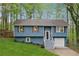 Charming home with blue siding, a well-manicured lawn, and mature trees at 2831 Pine Log Way, Buford, GA 30519