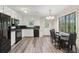 Bright kitchen with white cabinets, black appliances, and a dining area with large window at 2831 Pine Log Way, Buford, GA 30519