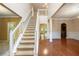 Bright foyer with hardwood floors and a staircase leading to the upper level, creating an inviting entry at 4312 Defoors Farm Trl, Powder Springs, GA 30127