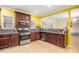 Well-lit kitchen with dark wood cabinetry, granite counters, and stainless steel appliances at 4312 Defoors Farm Trl, Powder Springs, GA 30127