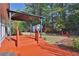 Backyard with a covered patio, stepping stone path, well-manicured landscaping, and storage shed at 1112 Autumn Glen Way, Dacula, GA 30019