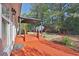 Wide shot of backyard featuring covered patio, stepping stone path, and lush landscaping at 1112 Autumn Glen Way, Dacula, GA 30019