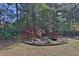 A small red bridge spans a decorative pond in a tranquil, landscaped backyard at 1112 Autumn Glen Way, Dacula, GA 30019