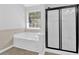Bathroom featuring a black framed shower and a tub beneath a window at 1112 Autumn Glen Way, Dacula, GA 30019