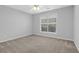 Neutral bedroom featuring large window, ceiling fan, and neutral color palette at 1112 Autumn Glen Way, Dacula, GA 30019
