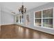 Bright dining room features wood floors, white trim, neutral walls, and a stylish chandelier at 1112 Autumn Glen Way, Dacula, GA 30019