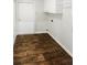This laundry room includes white cabinets, wood-look floors, and a doorway to the outside at 2252 Carefree Cir # 3, Marietta, GA 30062