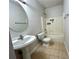Bathroom with a pedestal sink, toilet, and tiled shower at 2939 Stonecrest Ln, Lithonia, GA 30038