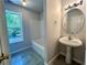 Bright bathroom with a pedestal sink, tiled floor, and a window view by the tub at 2939 Stonecrest Ln, Lithonia, GA 30038