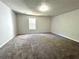 Large bonus room with plush carpeting, neutral walls, and natural light from single window at 2939 Stonecrest Ln, Lithonia, GA 30038