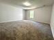 Large bonus room with plush carpeting, neutral walls, and natural light from single window at 2939 Stonecrest Ln, Lithonia, GA 30038