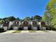 Street view of townhomes with brick and stone accents, garages, and well-maintained landscaping at 2939 Stonecrest Ln, Lithonia, GA 30038