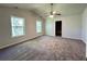 Spacious main bedroom features plush carpet, a ceiling fan, and natural light from two large windows at 2939 Stonecrest Ln, Lithonia, GA 30038
