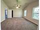 Large main bedroom boasts plush carpet, a ceiling fan, and bright natural light from two windows at 2939 Stonecrest Ln, Lithonia, GA 30038