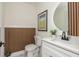 Stylish half bathroom featuring modern fixtures, trendy wall paneling, and unique geometric tile flooring at 3365 Ardley Sw Rd, Atlanta, GA 30311