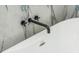 Close-up shot of a bathtub with marble background and black plumbing fixtures at 3365 Ardley Sw Rd, Atlanta, GA 30311