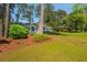 Well-manicured front lawn of white brick home showing mature trees and neighboring home at 3365 Ardley Sw Rd, Atlanta, GA 30311