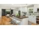 Bright, renovated kitchen with an island, white cabinets, and stainless steel appliances that opens up to the living room at 3365 Ardley Sw Rd, Atlanta, GA 30311
