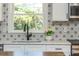 The kitchen features a patterned backsplash, white countertops and cabinets, and stainless steel appliances at 3365 Ardley Sw Rd, Atlanta, GA 30311