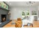 Inviting living room showcasing a painted brick fireplace, shiplap wall, and hardwood floors at 3365 Ardley Sw Rd, Atlanta, GA 30311