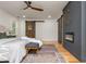 Stylish main bedroom featuring hardwood floors, a ceiling fan, and a gray accent wall with a cozy fireplace at 3365 Ardley Sw Rd, Atlanta, GA 30311