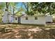 Backyard showcasing a charming white home with a picnic table under the shade of trees at 4301 Hidden Valley Rd, Decatur, GA 30035