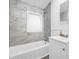 Bathroom featuring marble-style tiling and a clean white sink vanity and tub at 4301 Hidden Valley Rd, Decatur, GA 30035